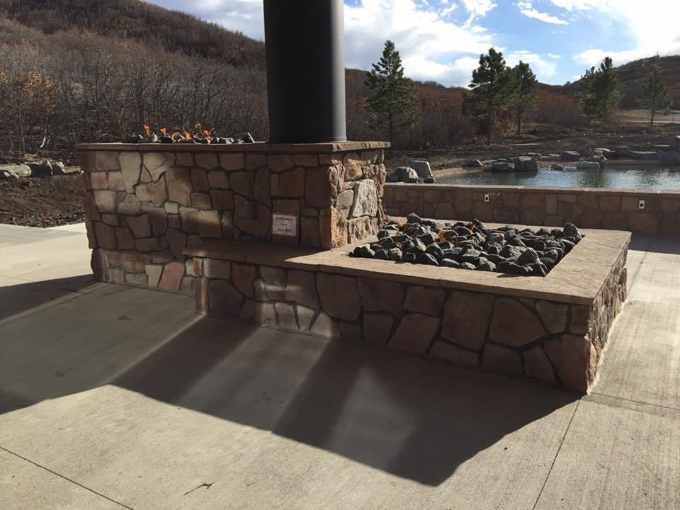 Stone-finished outdoor fire installation built on a modular frame